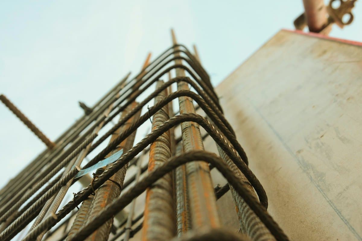 A column cage of steel reinforcement bars seen from below against the sky